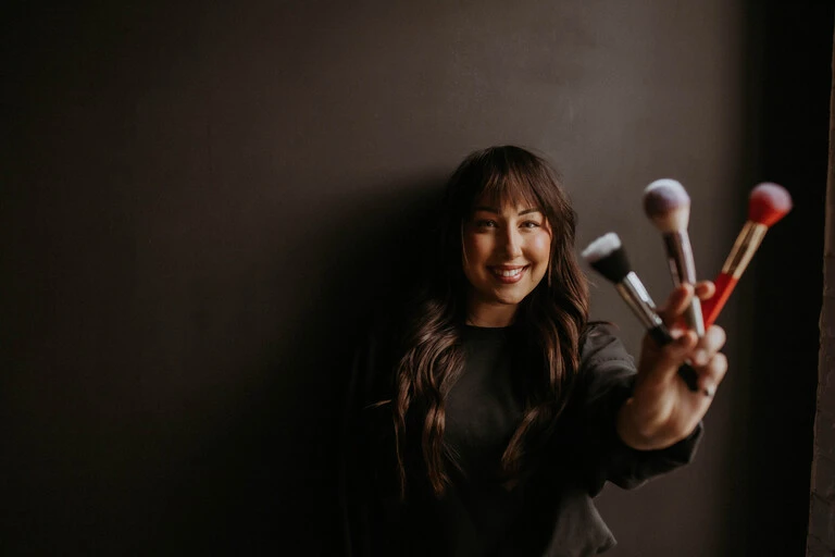 hannah makeup artist holding brushes